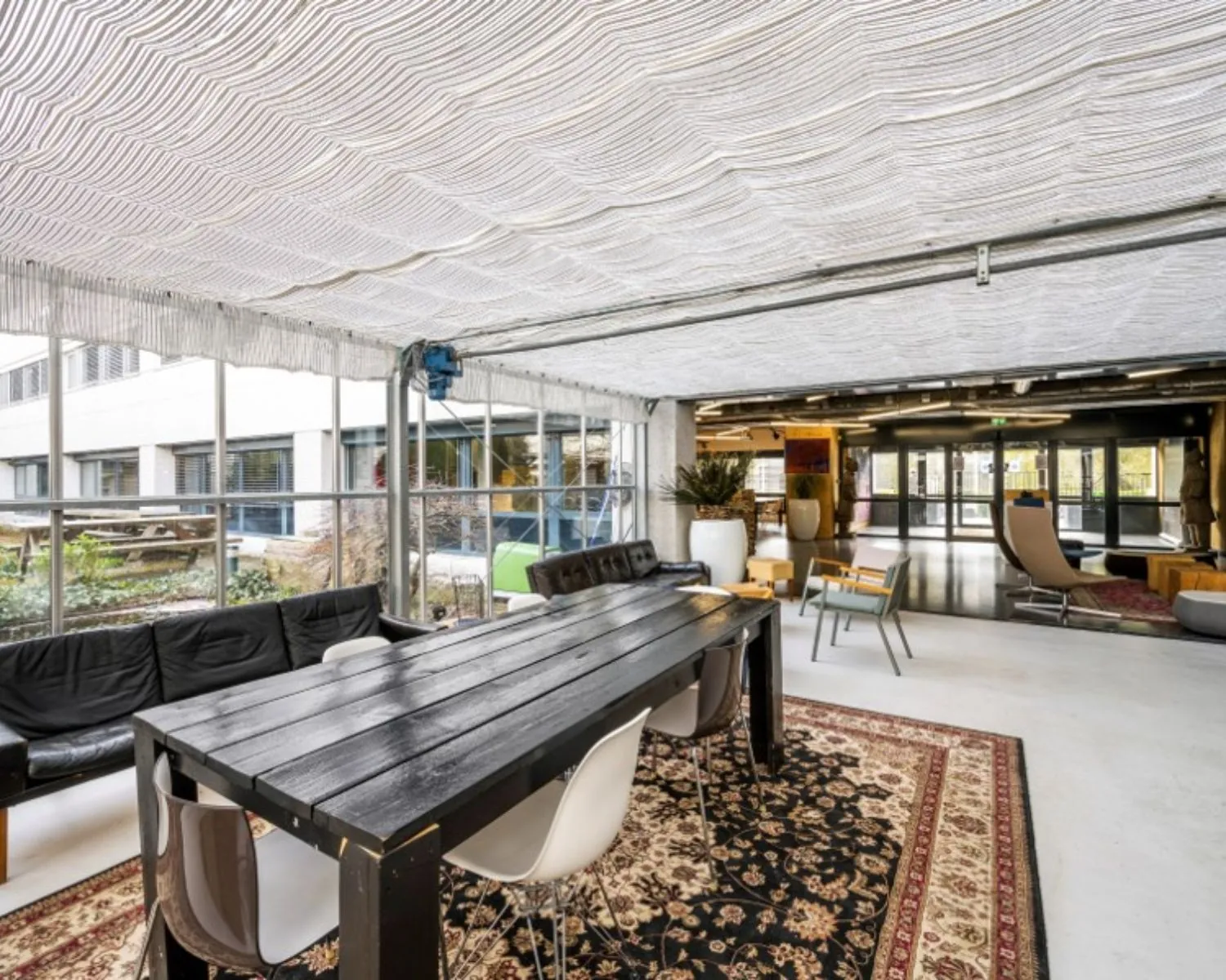 Gemeubileerde kantoorruimte in Diemermere 1 in Diemen met een lange vergadertafel, loungegedeelte en grote ramen met uitzicht op een binnentuin.