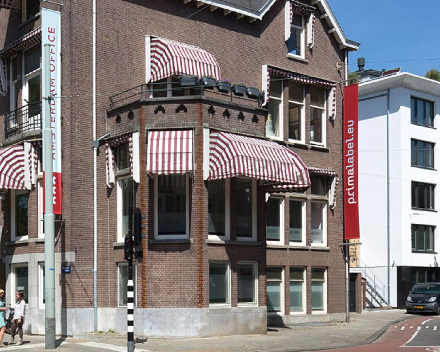 Klassiek kantoorpand aan de Emmalaan 25 in Amsterdam met rood-wit gestreepte zonwering.