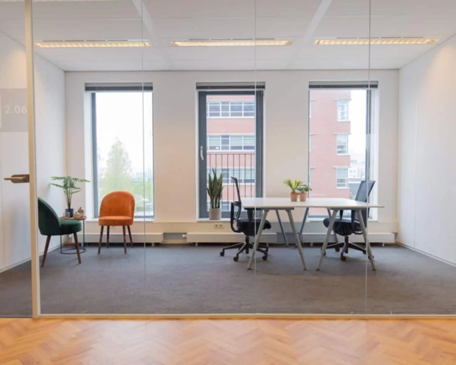 Moderne kantoorruimte aan de Fascinatio Boulevard 562 met grote ramen, bureaus, stoelen en planten.