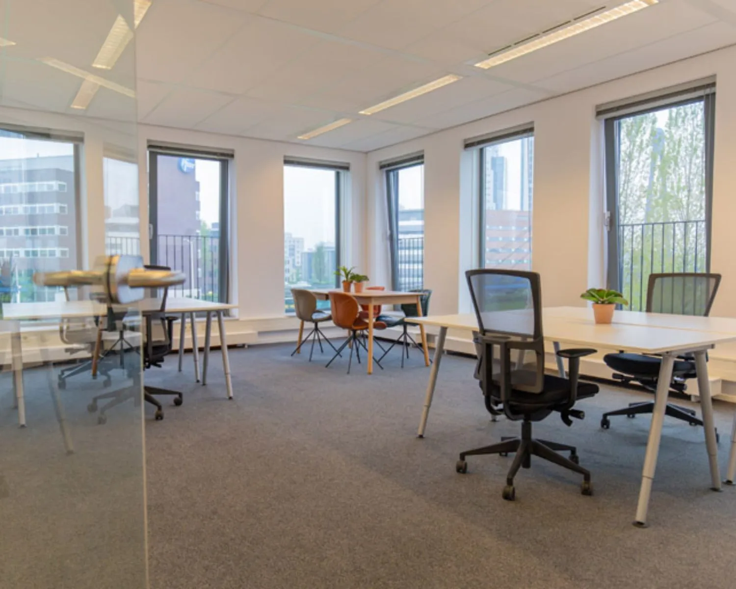 Moderne en lichte kantoorruimte aan de Fascinatio Boulevard 562 met bureaus, stoelen en grote ramen.