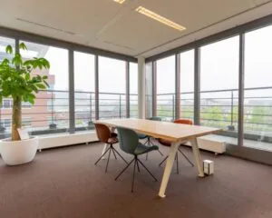 Moderne vergaderruimte aan de Fascinatio Boulevard 562 met grote ramen, designstoelen en een houten tafel.