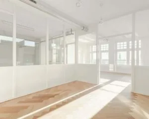 Lichte, moderne kantoorruimte met glazen scheidingswanden en visgraat houten vloer aan de Geldersekade 101.