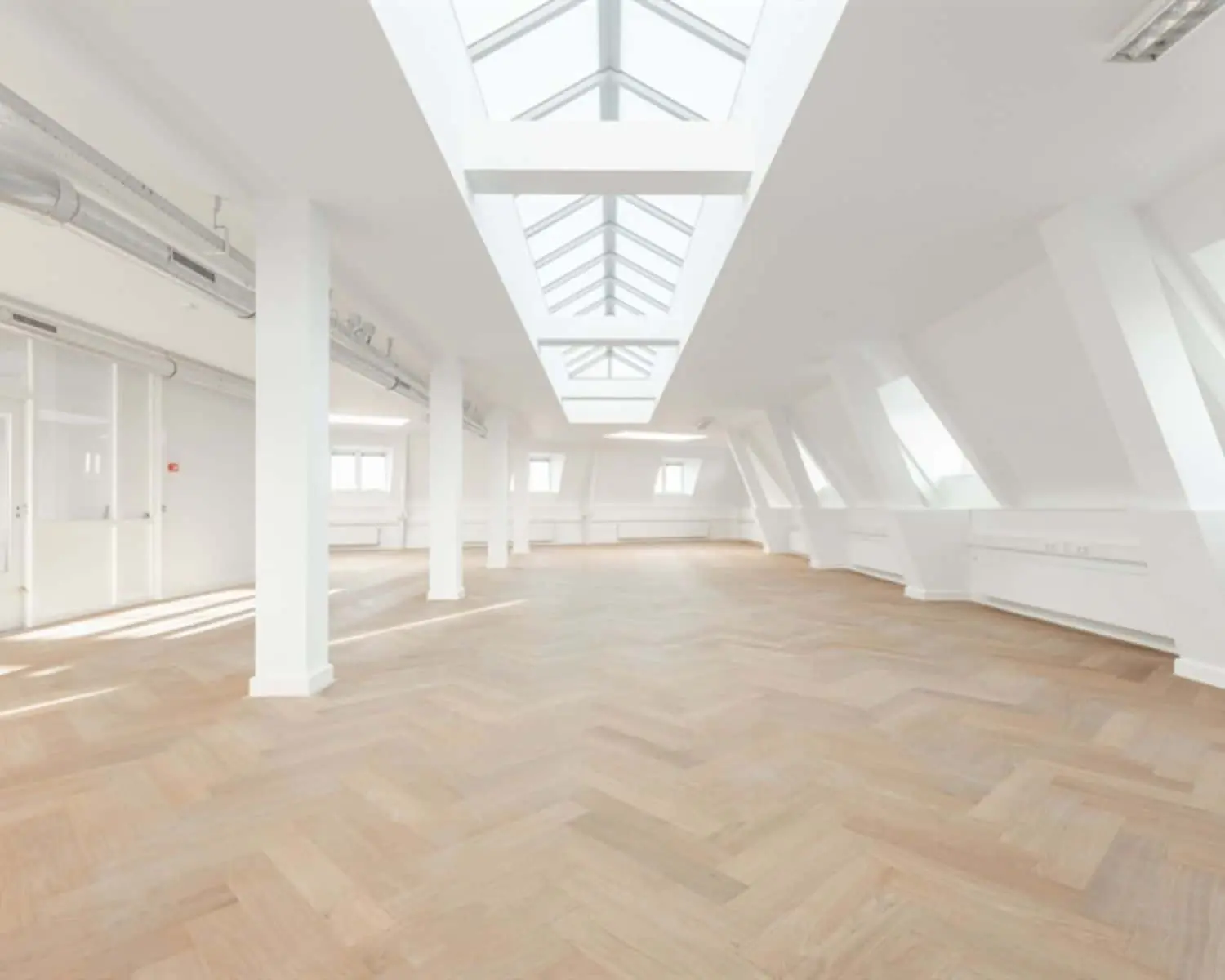 Lichte, moderne kantoorruimte met houten visgraatvloer en grote dakramen aan de Geldersekade 101.