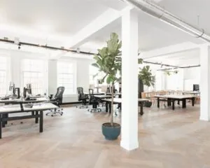 Lichte en moderne kantoorruimte aan de Geldersekade 101 met open werkplekken, houten vloer en grote ramen.