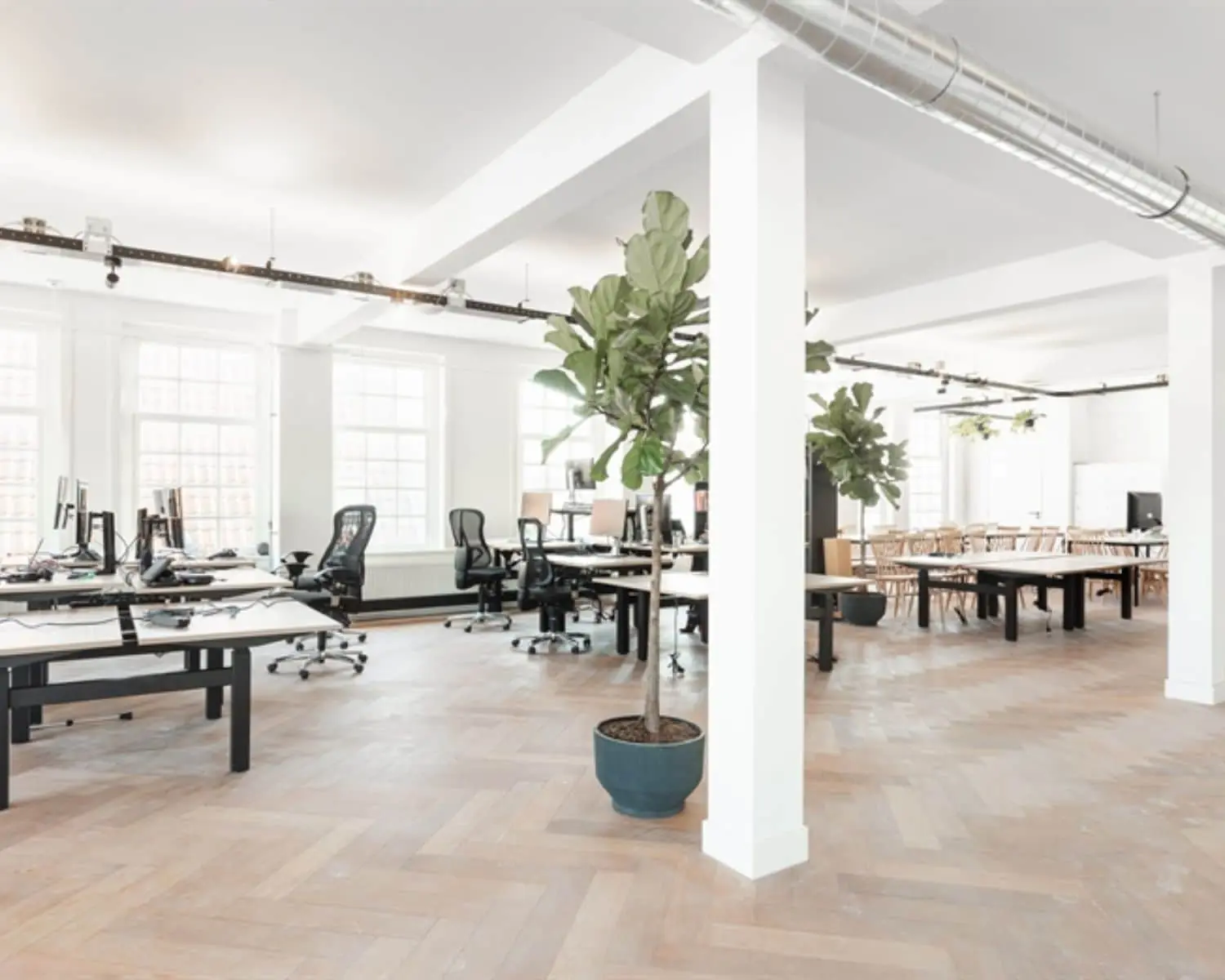 Lichte en moderne kantoorruimte aan de Geldersekade 101 met open werkplekken, houten vloer en grote ramen.