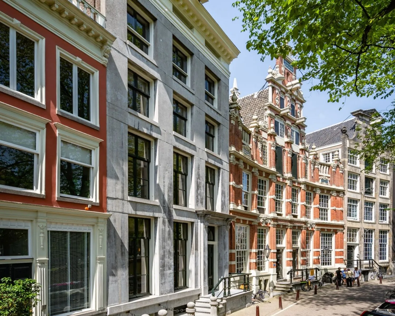 Gevels van karakteristieke grachtenpanden aan de Herengracht 174 in Amsterdam op een zonnige dag.