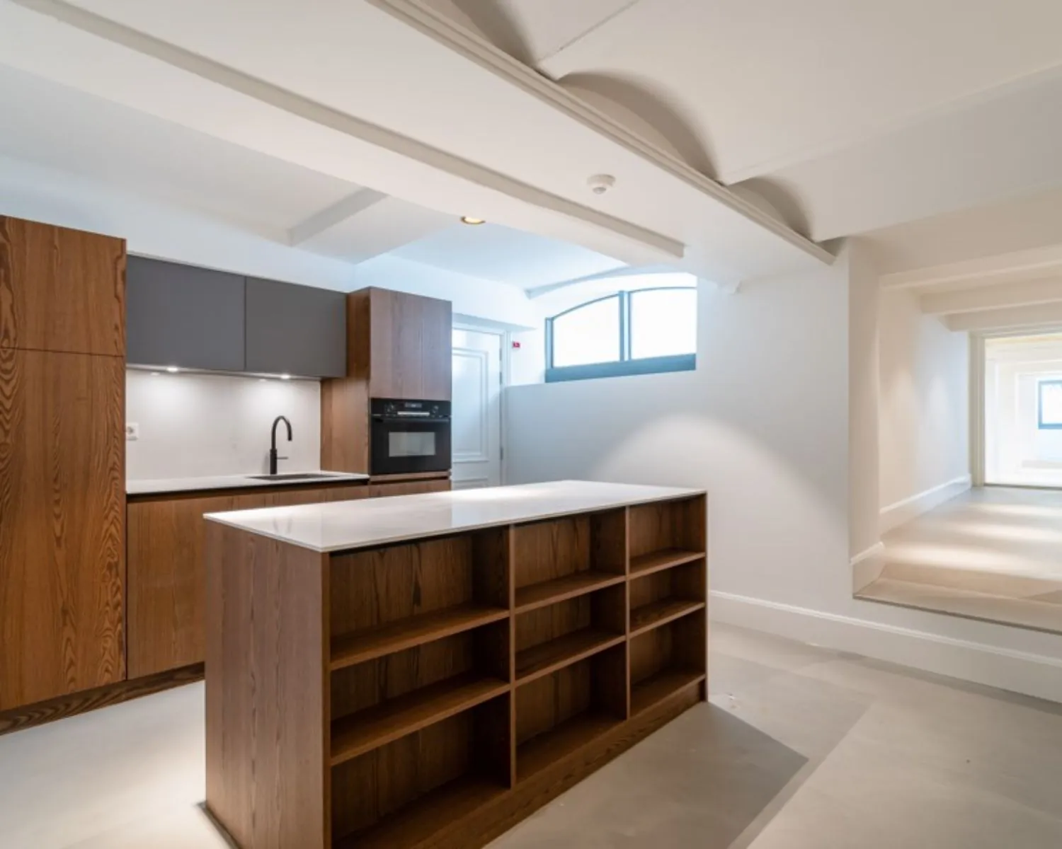 Moderne kitchenette met houten afwerking en kookeiland in een kantoorruimte aan de Herengracht 174 in Amsterdam.
