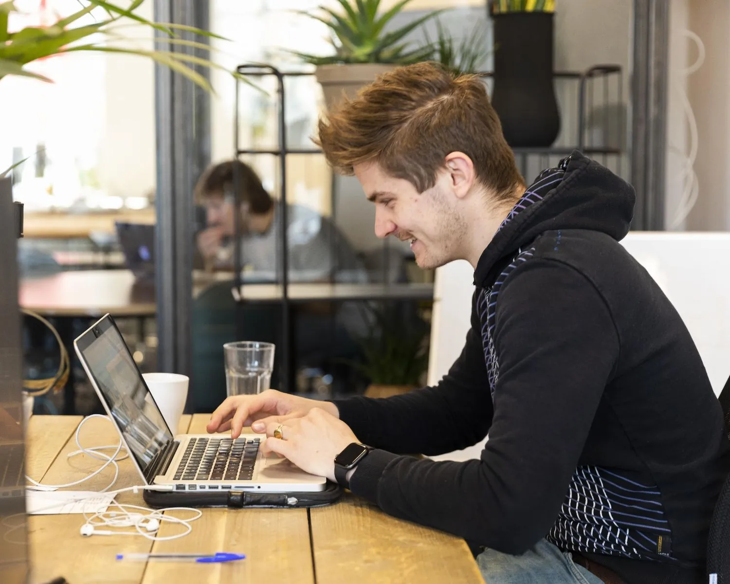 Man werkt op een laptop in een moderne kantoorruimte aan de Herengracht 420 in Amsterdam.