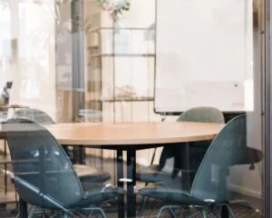 Vergaderruimte met ronde houten tafel en vier moderne stoelen in kantoor aan de Herengracht 420 in Amsterdam.