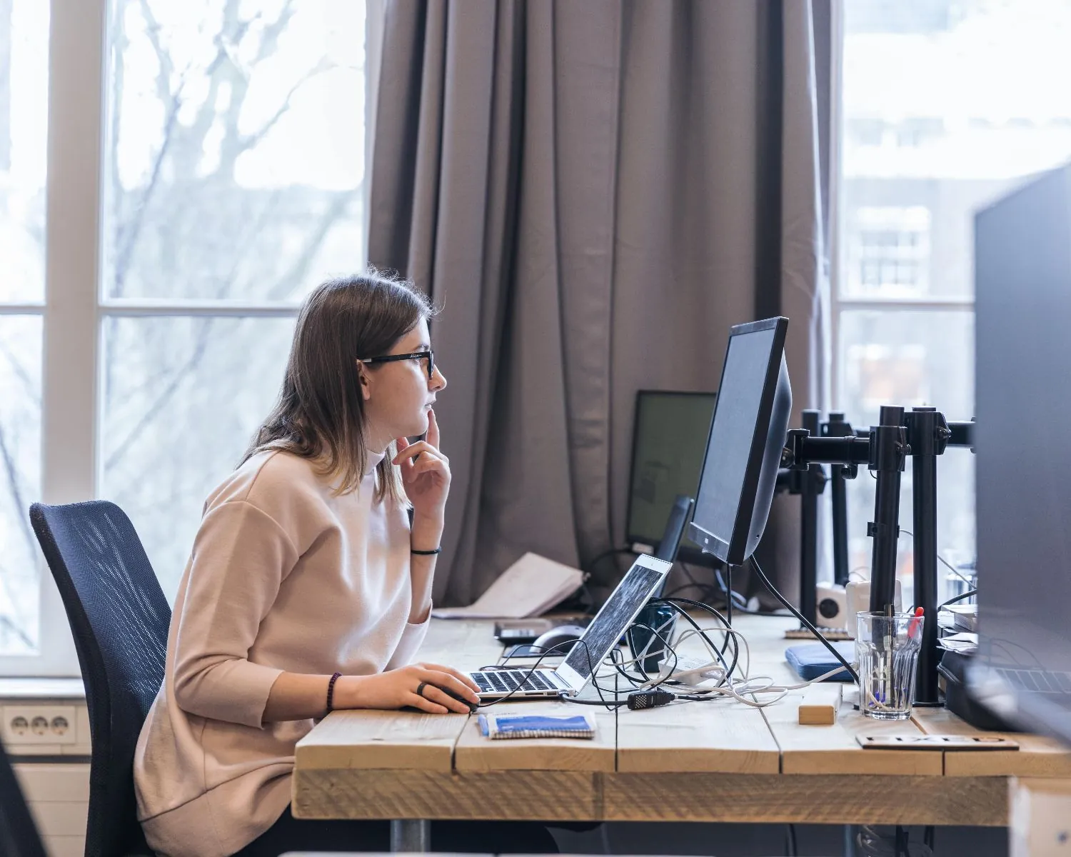 Vrouw werkt geconcentreerd aan een bureau in een moderne kantoorruimte aan de Herengracht 420 in Amsterdam.