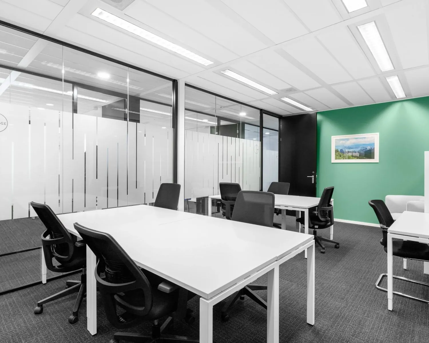 Moderne kantoorruimte met witte bureaus en zwarte stoelen aan de Johan Cruijff Boulevard.