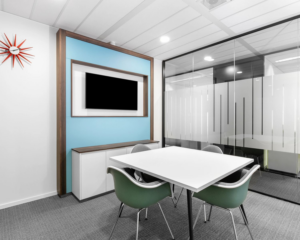 Moderne vergaderruimte met glazen wanden, een witte tafel, designstoelen en een flatscreen aan de Johan Cruijff Boulevard 7.