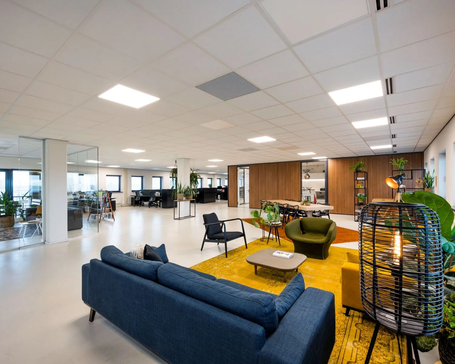 Moderne en open kantoorruimte aan de Joop Geesinkweg 140-199 in Amsterdam met loungeset, vergadertafel en werkplekken.