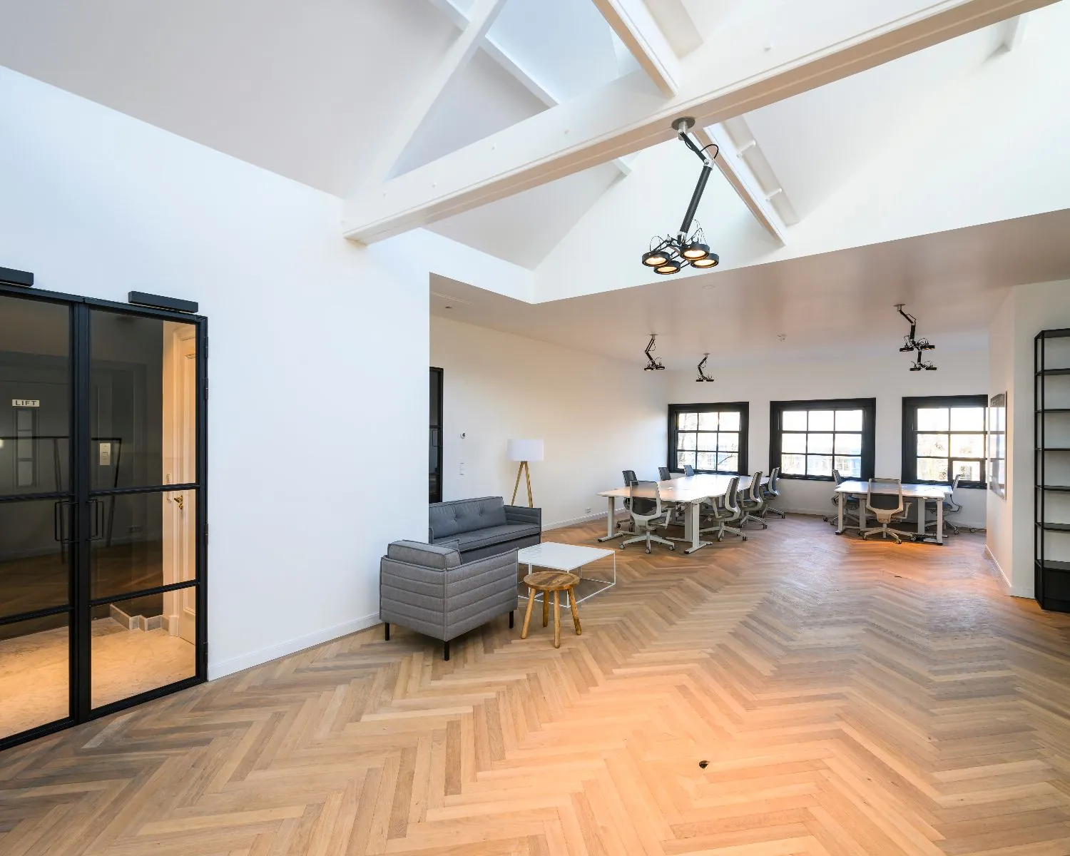 Moderne, lichte kantoorruimte met houten visgraatvloer aan de Keizersgracht 121 in Amsterdam.