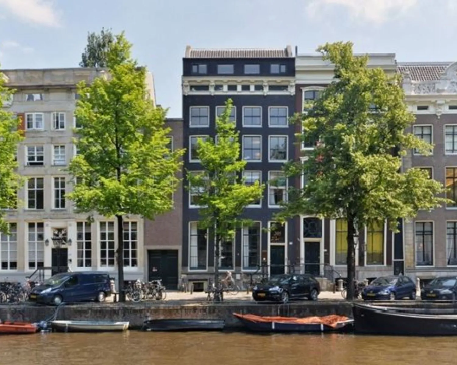 Gevel van het kantoorpand aan de Keizersgracht 205 in Amsterdam met uitzicht op de gracht en geparkeerde auto's.