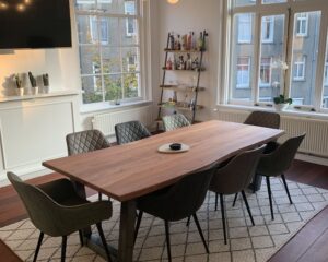 Stijlvol ingerichte vergaderruimte aan de Keizersgracht 205 in Amsterdam met grote houten tafel, acht stoelen en natuurlijk licht.