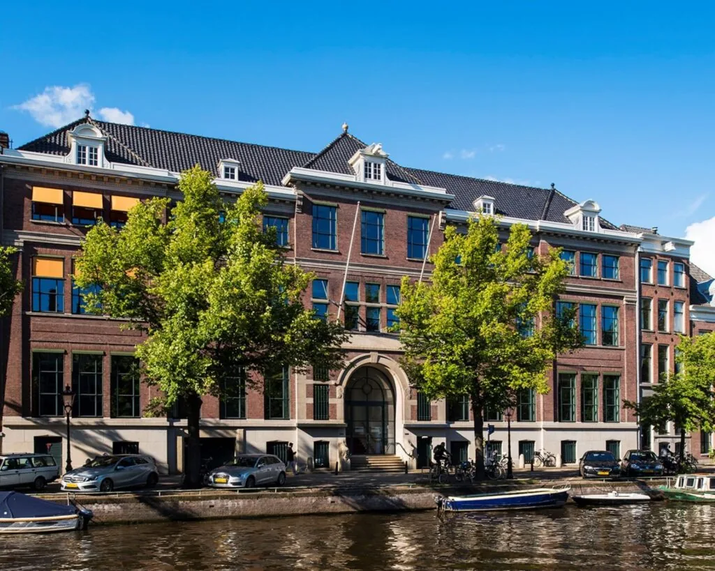Gevel van een statig kantoorpand aan de Keizersgracht 617 in Amsterdam, met zicht op de gracht en geparkeerde auto's.