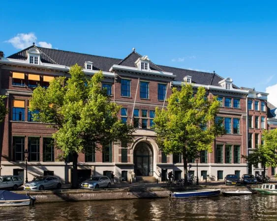 Gevel van een statig kantoorpand aan de Keizersgracht 617 in Amsterdam, met zicht op de gracht en geparkeerde auto's.