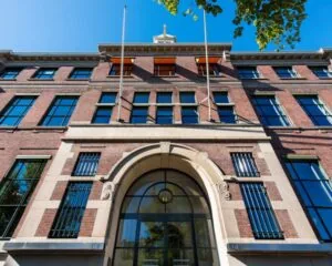 Vooraanzicht van een klassiek kantoorgebouw aan de Keizersgracht 617 in Amsterdam met grote ramen en een stenen boogingang.