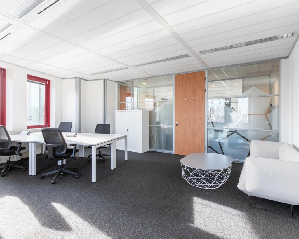 Moderne en lichte kantoorruimte met bureaus, stoelen en een zithoek aan de Kingsfortweg 151 in Amsterdam.