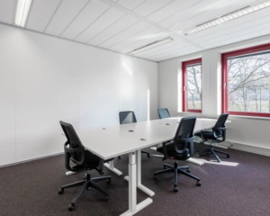 Moderne kantoorruimte met vier bureaustoelen en grote ramen aan de Kingsfortweg 151 in Amsterdam.