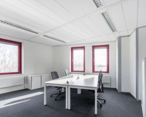 Moderne kantoorruimte met twee bureaus en rode kozijnen aan de Kingsfortweg 151 in Amsterdam.