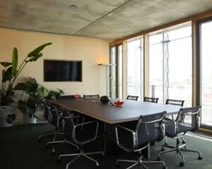 Moderne vergaderruimte in kantoor aan Kraanspoor 12 in Amsterdam met een lange tafel, designstoelen, grote ramen en veel natuurlijk licht.