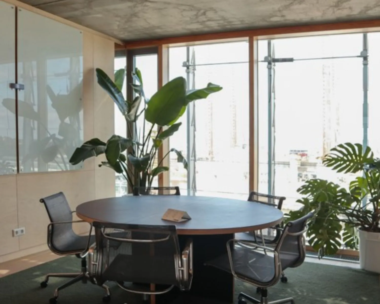 Moderne vergaderruimte in kantoor aan Kraanspoor 12 in Amsterdam met ronde tafel, designstoelen en grote ramen met uitzicht.
