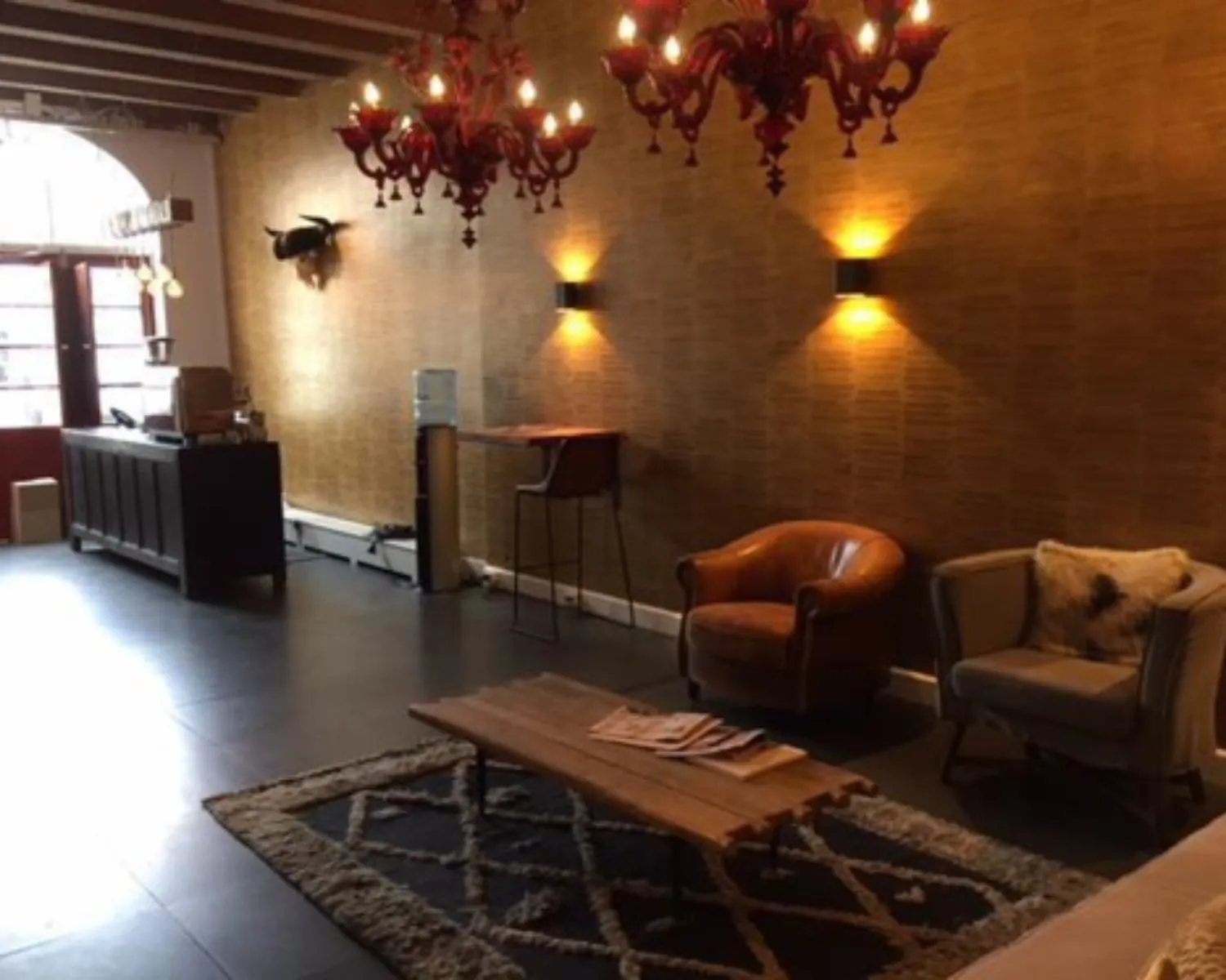 Sfeervolle kantoorruimte aan het Molenpad 3 in Amsterdam met loungehoek, houten accenten en warme verlichting.