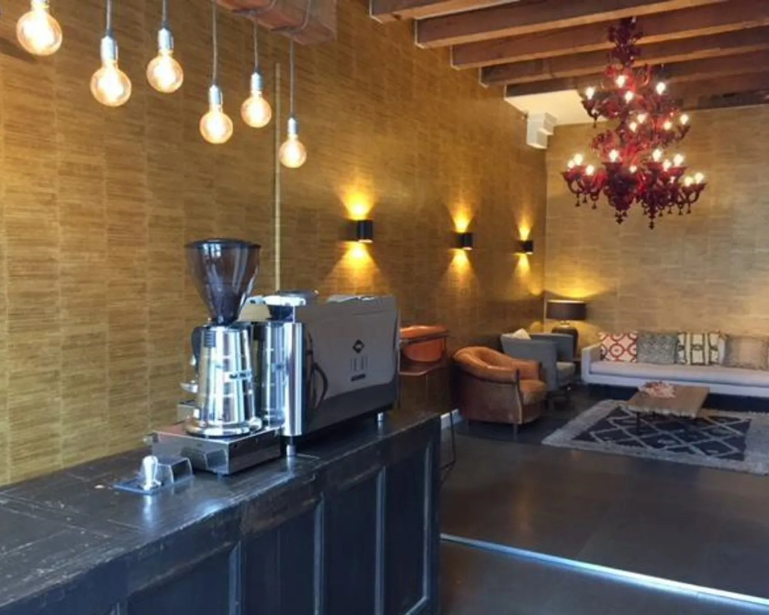 Stijlvol ingerichte loungehoek met koffiemachine in kantoorruimte aan het Molenpad 3 in Amsterdam.