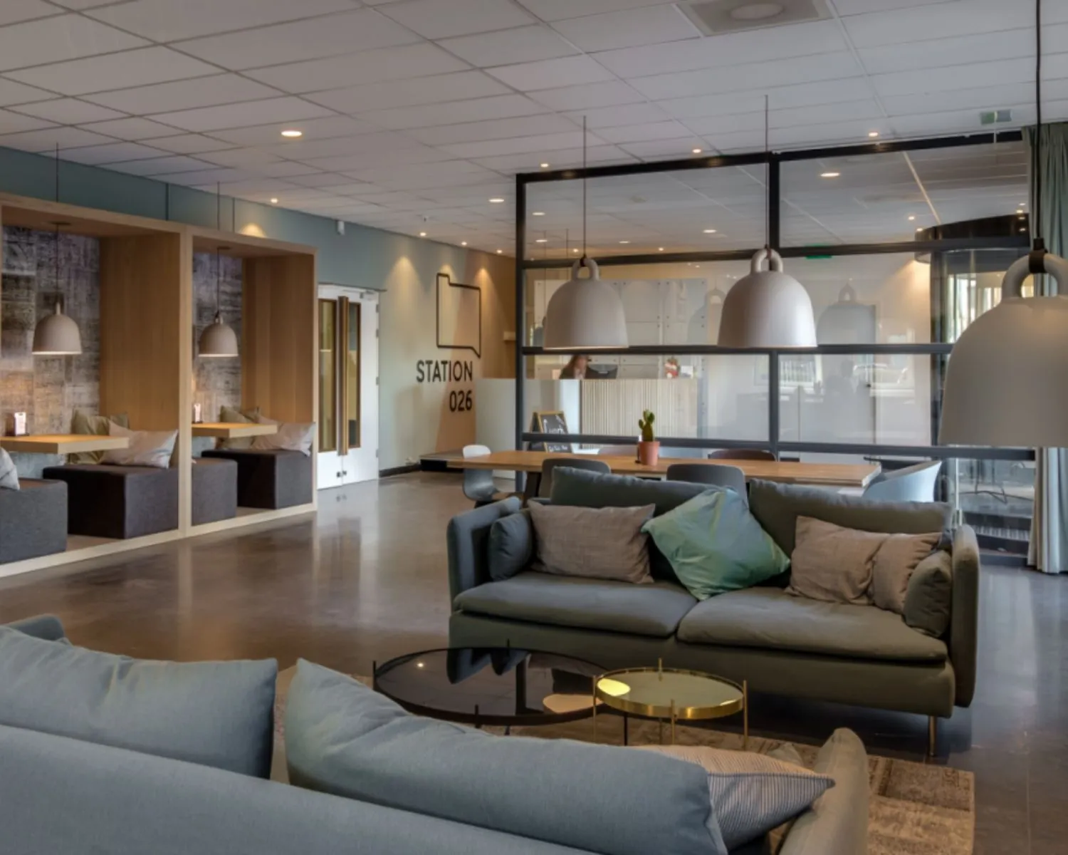 Moderne, gemeubileerde kantoorruimte met zithoeken en vergadertafels in Station 026 aan de Mr. E.N. van Kleffenstraat 6 in Arnhem.