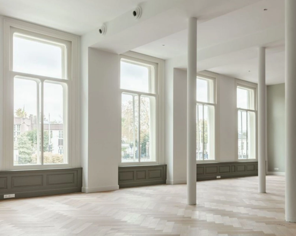 Lichte en ruime kantoorruimte met hoge ramen aan de Nieuwe Herengracht 95 in Amsterdam.