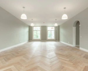 Lichte, lege kantoorruimte met visgraatvloer en grote ramen aan de Nieuwe Herengracht 95 in Amsterdam.