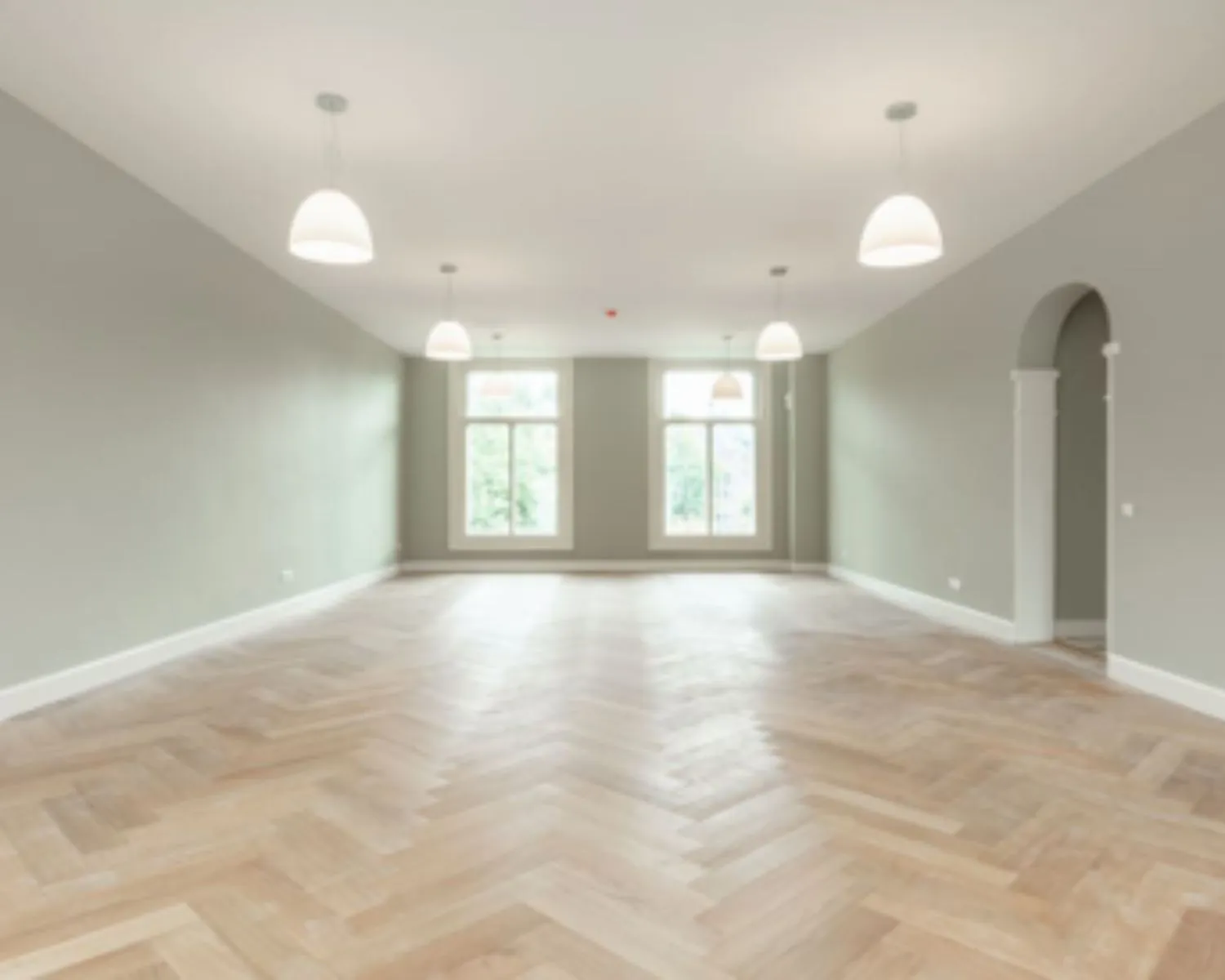 Lichte, lege kantoorruimte met visgraatvloer en grote ramen aan de Nieuwe Herengracht 95 in Amsterdam.