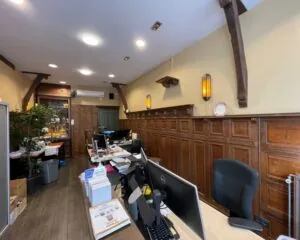 Traditioneel ingerichte kantoorruimte aan de Nieuwezijds Voorburgwal 314 met houten lambrisering en moderne werkplekken.