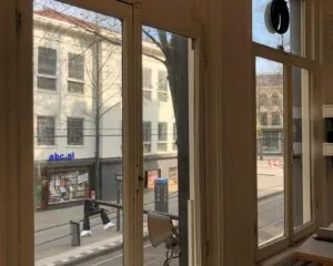 Uitzicht vanuit een kantoorruimte aan de Nieuwezijds Voorburgwal in Amsterdam op de straat en tegenoverliggende gebouwen.