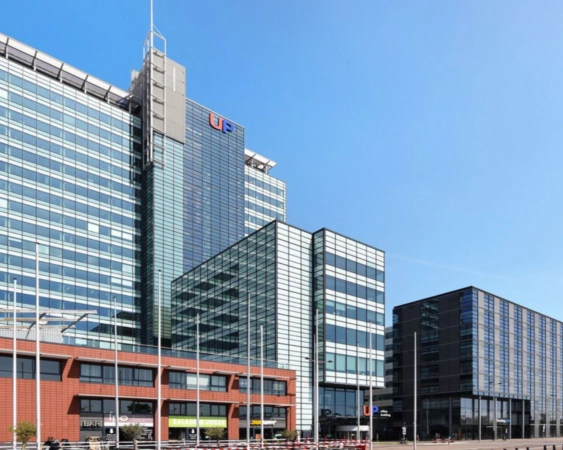 Moderne kantoorgebouwen aan de Piet Heinkade 55 in Amsterdam met glazen gevels en het UP-gebouw prominent in beeld.