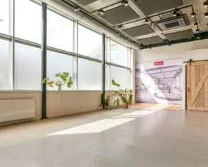 Lichte en moderne kantoorruimte met grote ramen, planten en een houten schuifdeur in Poortland 242.