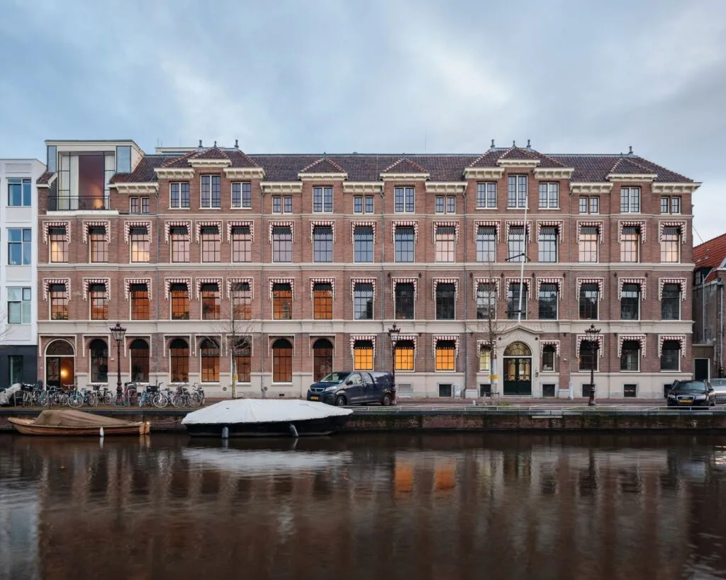 Monumentaal kantoorgebouw aan de Prinsengracht 769 in Amsterdam, gelegen aan het water met boten en fietsen ervoor.