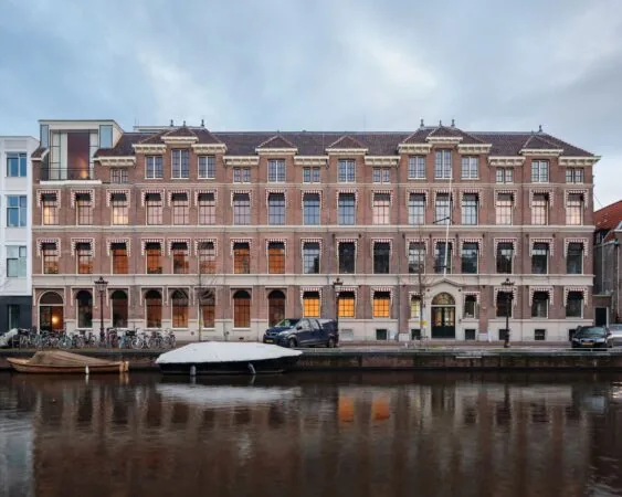 Monumentaal kantoorgebouw aan de Prinsengracht 769 in Amsterdam, gelegen aan het water met boten en fietsen ervoor.