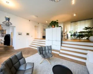 Modern ingerichte kantoorruimte aan de Sarphatistraat in Amsterdam met een split-level indeling, loungehoek en veel natuurlijk licht.