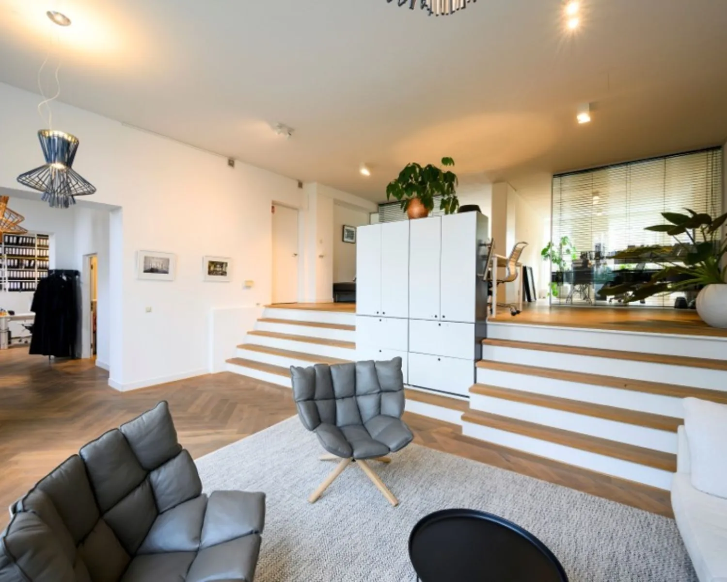 Modern ingerichte kantoorruimte aan de Sarphatistraat in Amsterdam met een split-level indeling, loungehoek en veel natuurlijk licht.