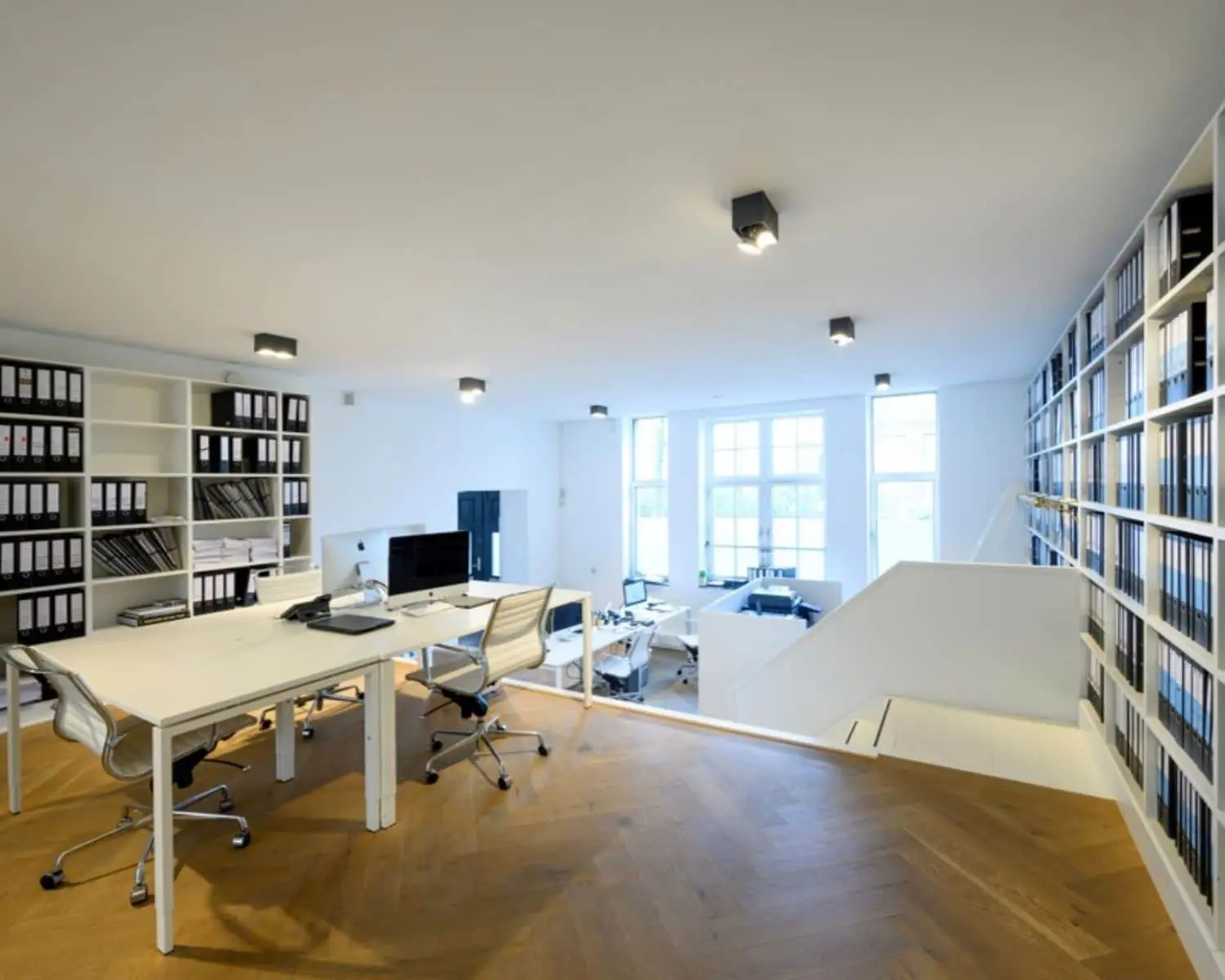 Moderne, lichte kantoorruimte met werkplekken en archiefkasten aan de Sarphatistraat 640-642 in Amsterdam.