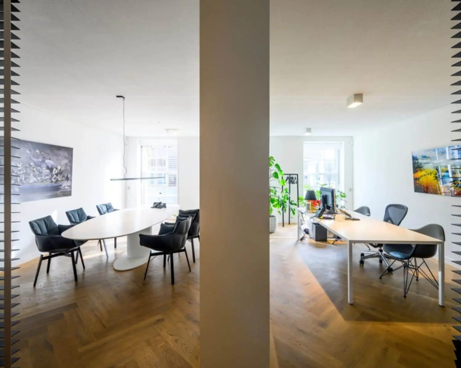 Moderne kantoorruimte aan de Sarphatistraat in Amsterdam met een vergaderruimte en werkplekken, gescheiden door een centrale wand.