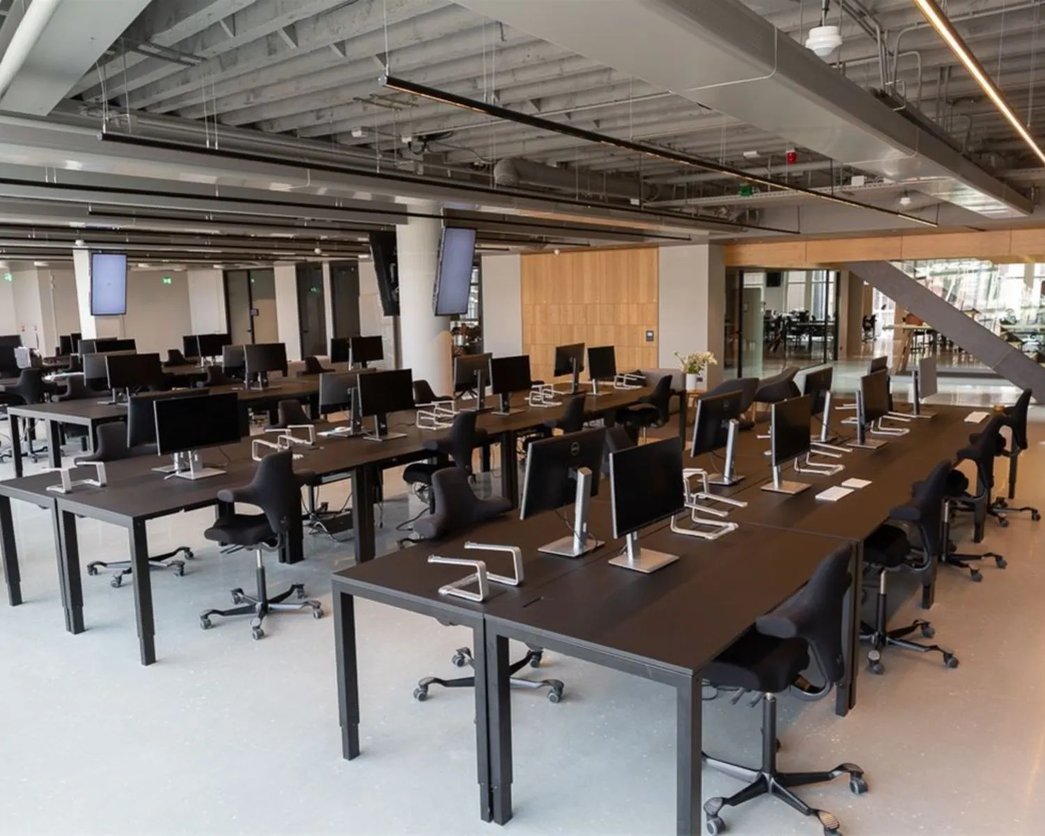 Moderne, open kantoorruimte met meerdere werkplekken en computers aan de Sint Jorissteeg 2 in Amsterdam.