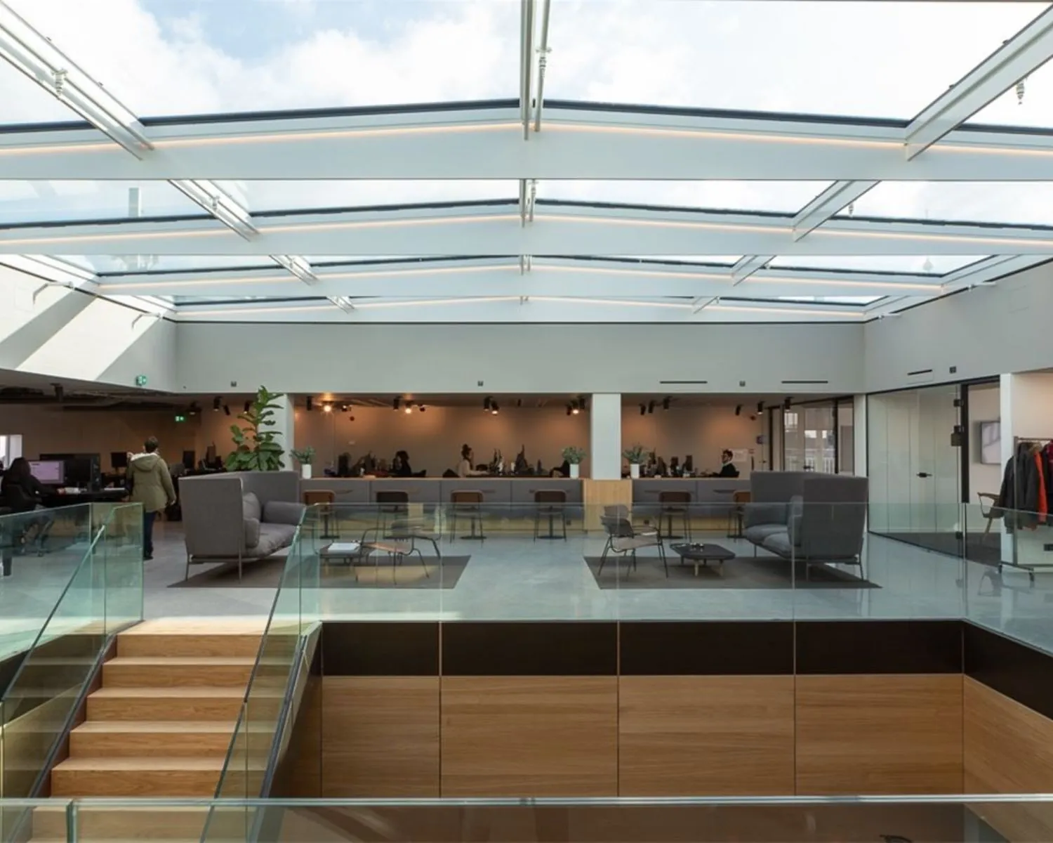 Moderne kantoorruimte met glazen dak, zithoeken en werkplekken aan de Sint Jorissteeg 2 in Amsterdam.