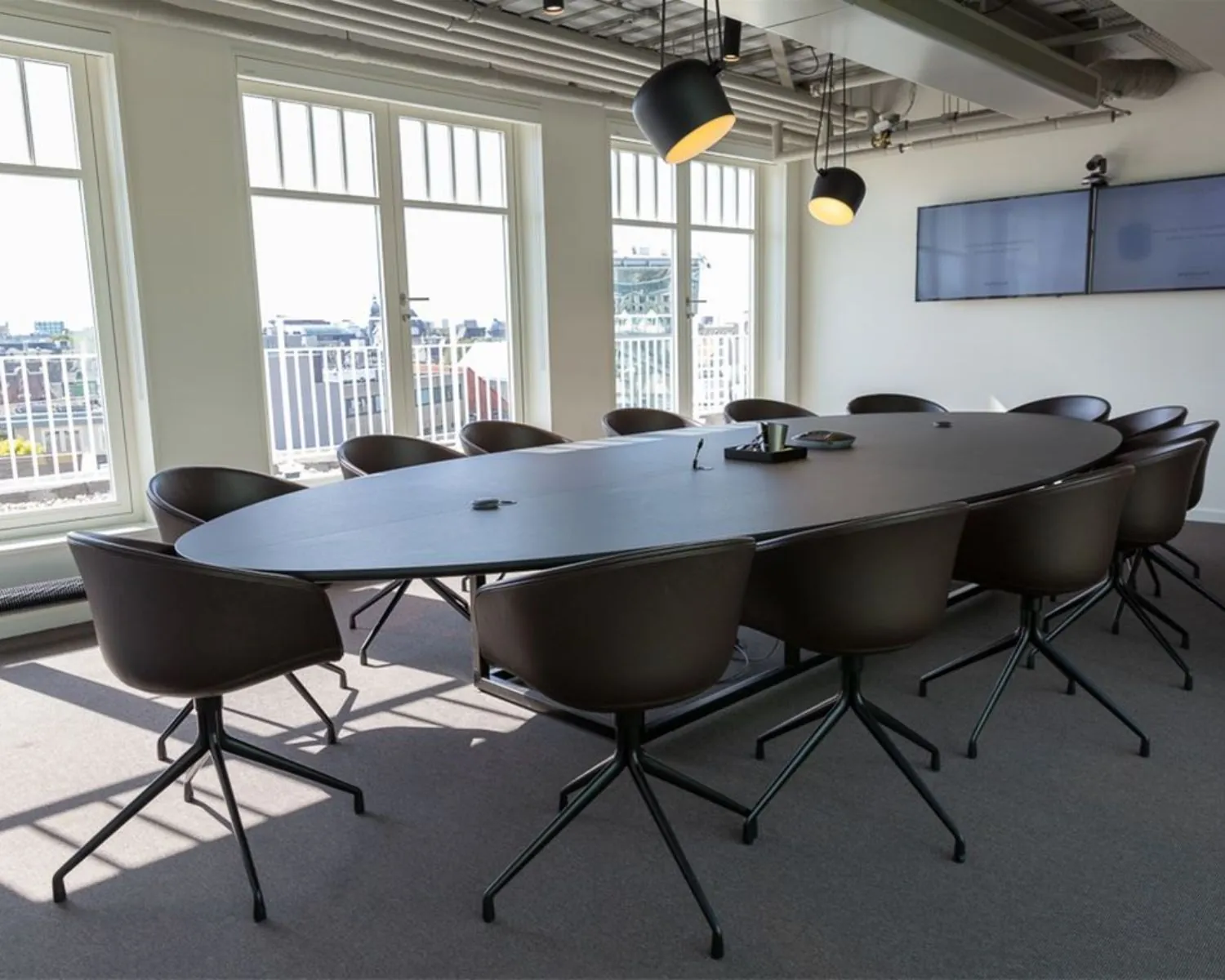 Vergaderruimte met ovale tafel en moderne stoelen in kantoor aan de Sint Jorissteeg 2 in Amsterdam.