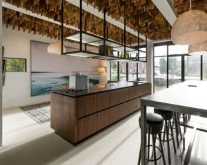 Moderne kantoorruimte aan de Sloterweg 796 in Amsterdam met een open keuken, hoge tafels en creatieve plafondafwerking.