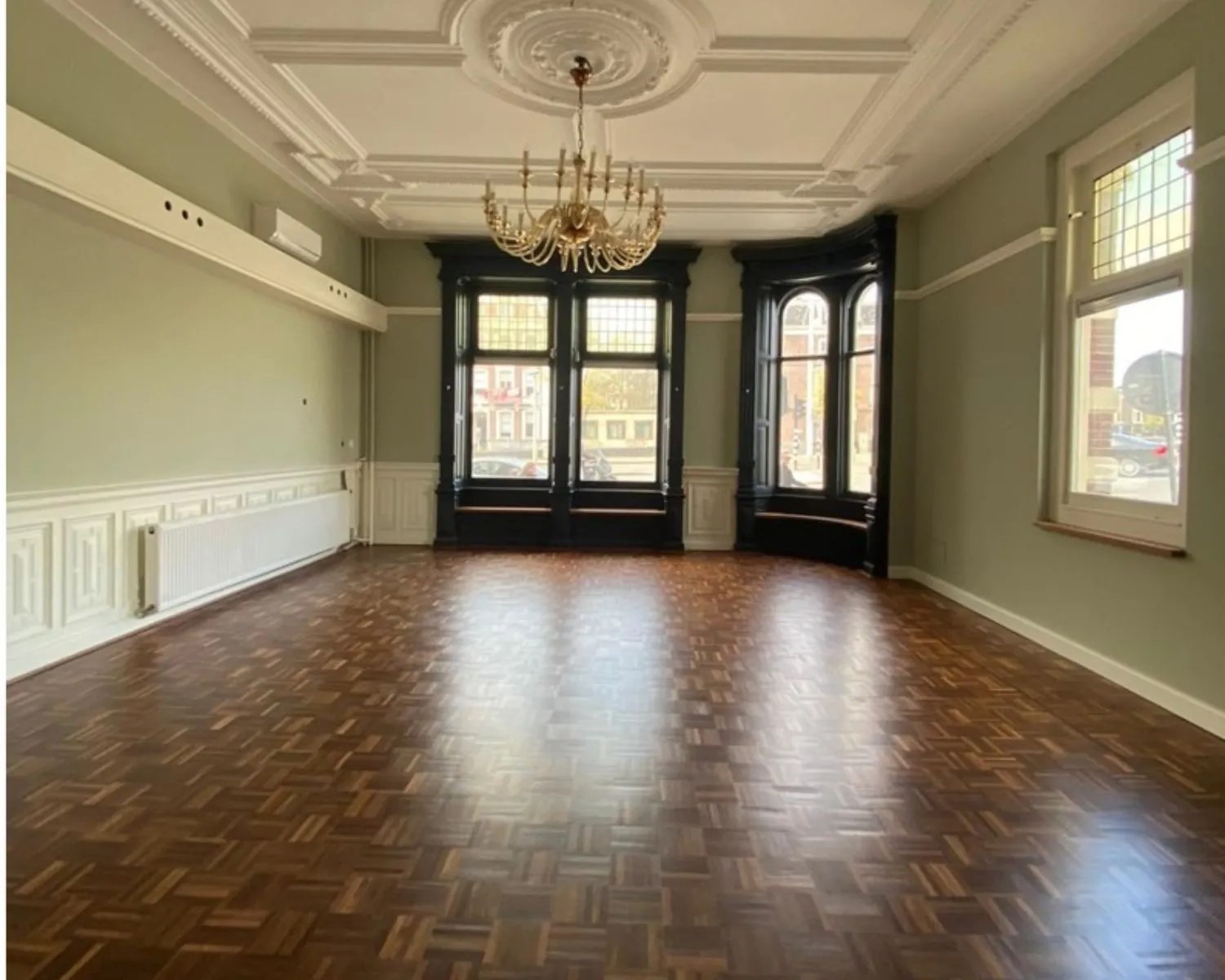 Ruime, klassieke kantoorruimte aan de Stadhouderskade 160 in Amsterdam met visgraatvloer, hoge plafonds en sierlijke houten details.