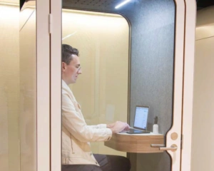 Man werkt op een laptop in een stille werkpod in kantoorruimte TNW.